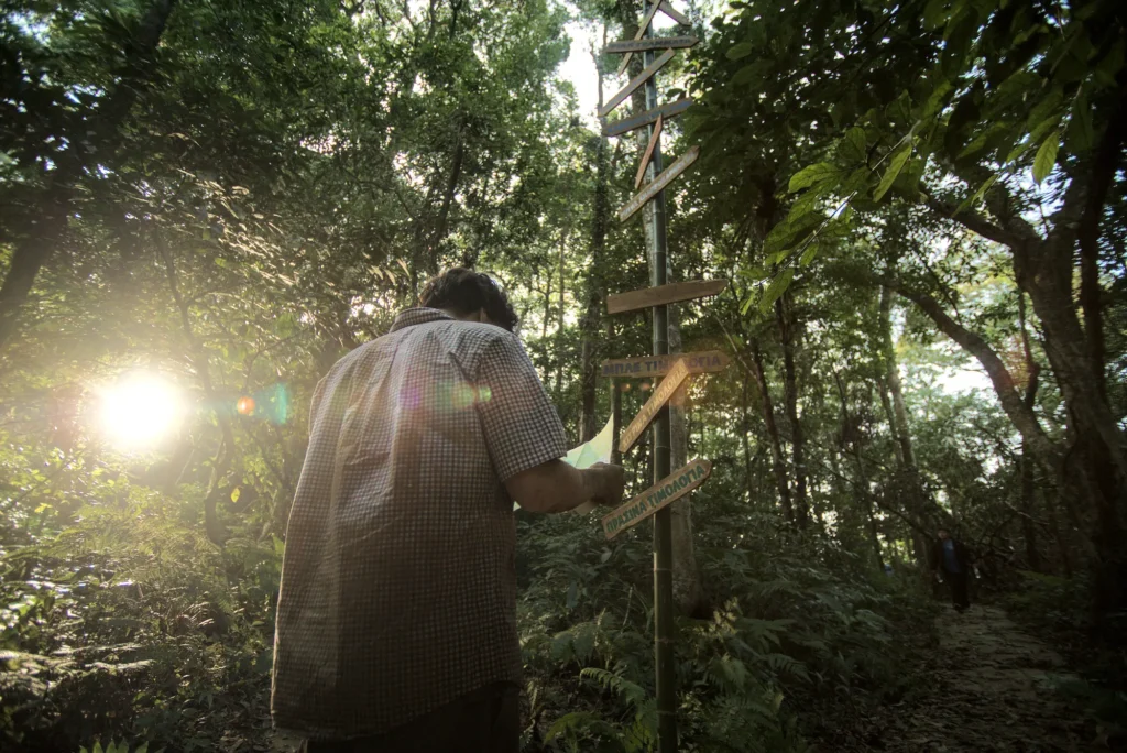 a man stands at a crossroads with a map. he has lost his way